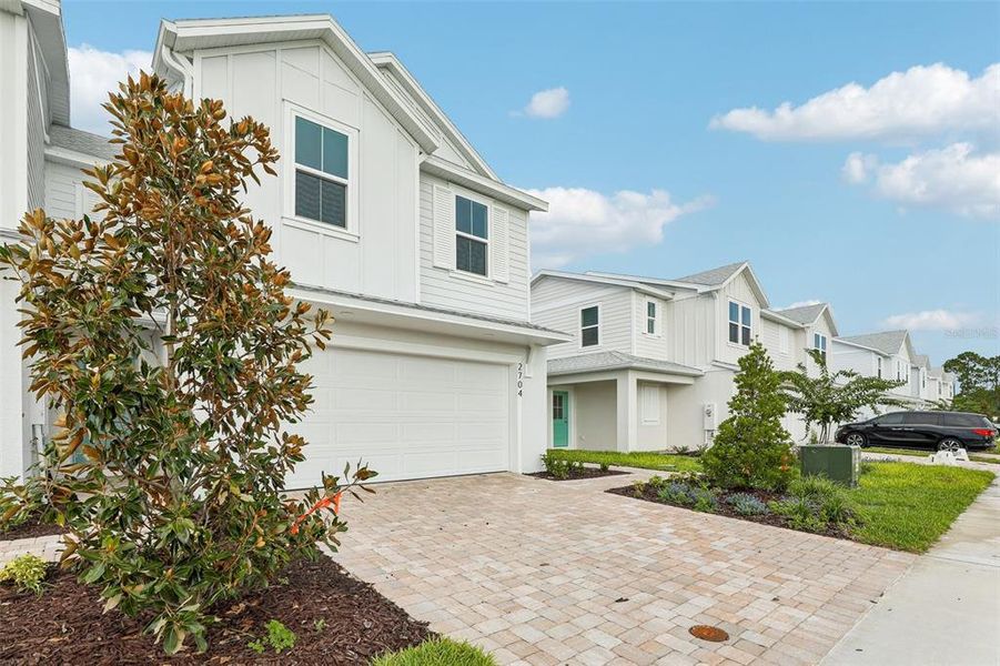 Front exterior of a new home in Cyrene at Harmony, St. Cloud, FL, highlighting curb appeal (Image 2). Front exterior of a new home in Cyrene at Harmony, St. Cloud, FL, highlighting curb appeal (Image 2).