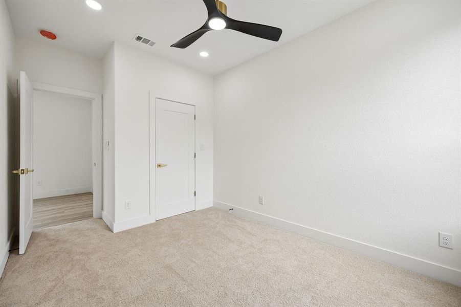 Carpeted room with recessed lighting and a modern black and gold ceiling fan Carpeted room with recessed lighting and a modern black and gold ceiling fan