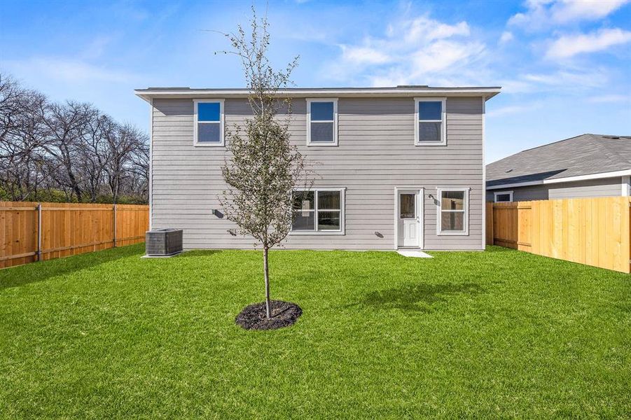 Rear view of house featuring central AC and a yard