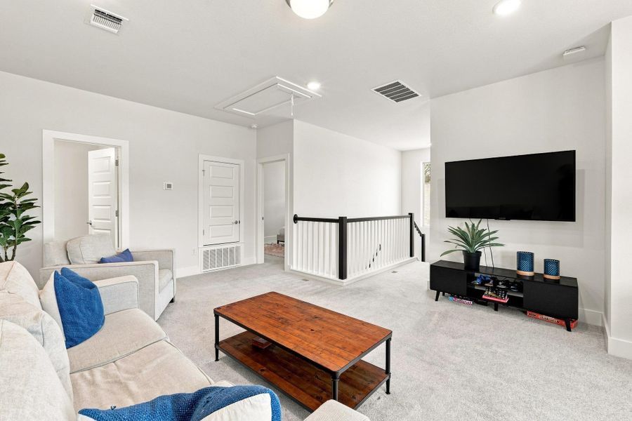 Alternate loft view showing the wrought iron rail overlook, secondary TV setup space, and access to upstairs bedrooms. Alternate loft view showing the wrought iron rail overlook, secondary TV setup space, and access to upstairs bedrooms.