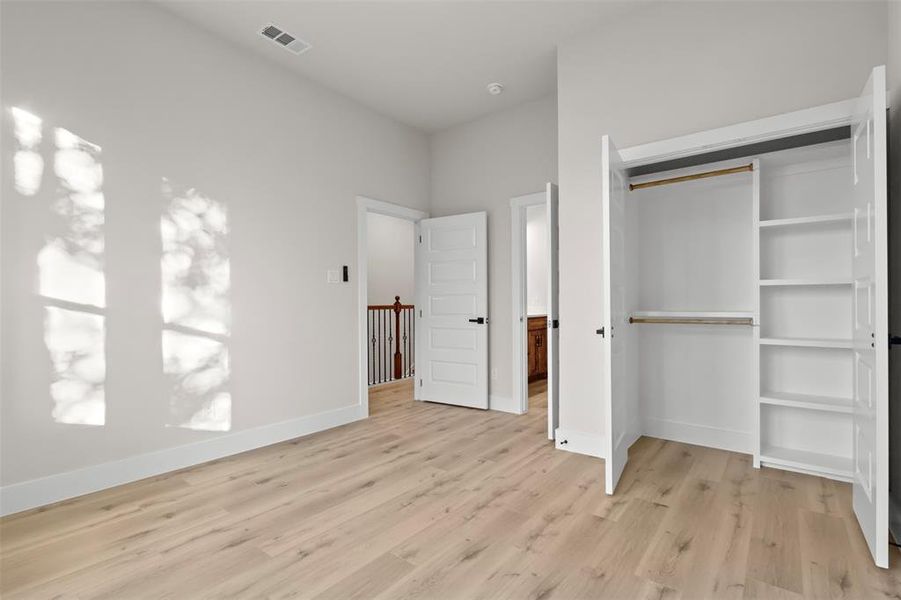 Unfurnished bedroom with light hardwood / wood-style floors and a closet