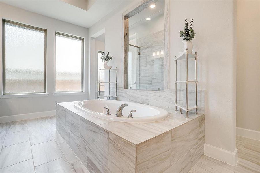 Bathroom with a garden tub, baseboards, a tile shower, and recessed lighting Bathroom with a garden tub, baseboards, a tile shower, and recessed lighting