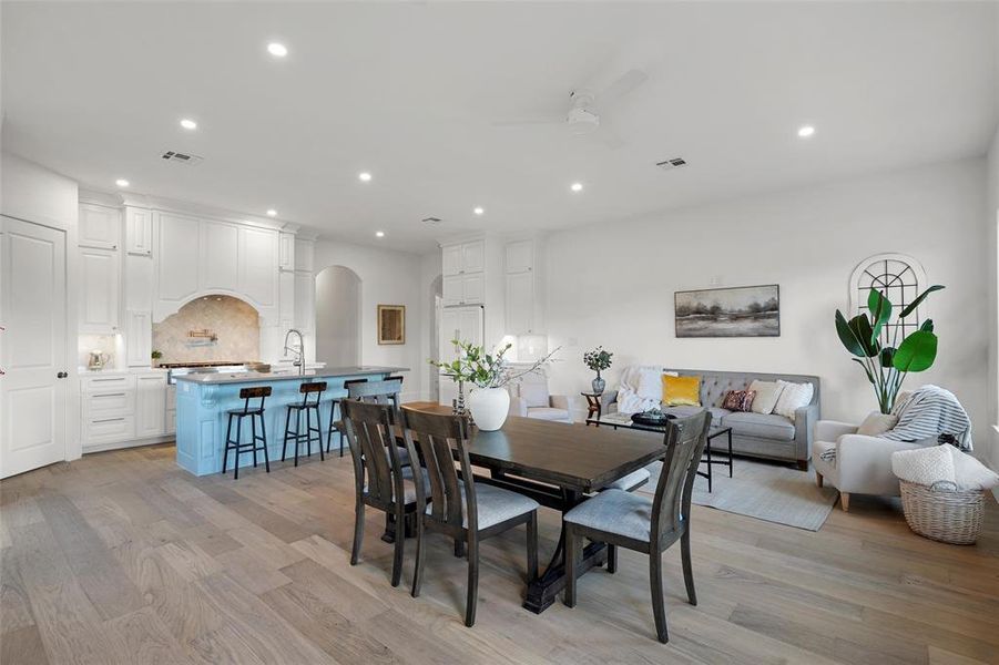 Dining room featuring arched walkways, light wood-type flooring, recessed lighting, and ceiling fan Dining room featuring arched walkways, light wood-type flooring, recessed lighting, and ceiling fan