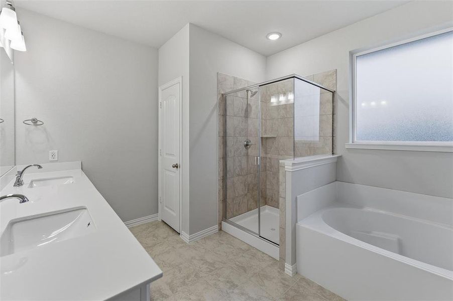 Bathroom featuring a white dual vanity with undermount sinks, a walk-in shower with tile surround and glass enclosure, a built-in bathtub, and a frosted window Bathroom featuring a white dual vanity with undermount sinks, a walk-in shower with tile surround and glass enclosure, a built-in bathtub, and a frosted window