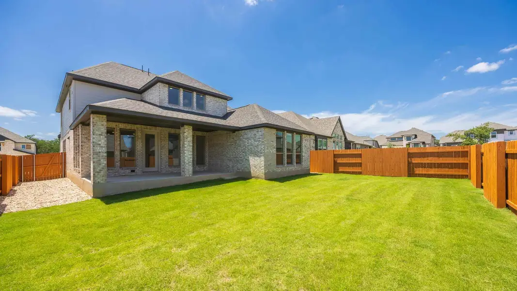 Rear view of house featuring brick siding, a fenced backyard, and a shingled roof Rear view of house featuring brick siding, a fenced backyard, and a shingled roof