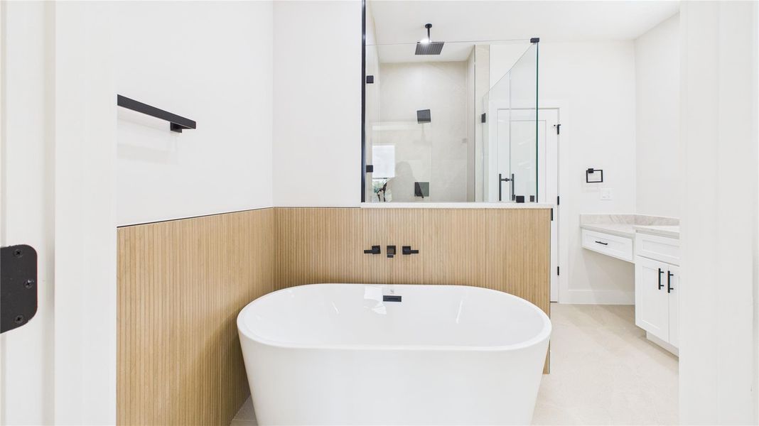 This modern bathroom features a sleek freestanding bathtub, wood panel accents, a spacious glass-enclosed shower, and contemporary fixtures, creating a stylish and relaxing atmosphere.