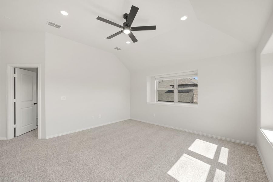 Empty bedroom with vaulted ceiling, black ceiling fan, carpet flooring, and a single window