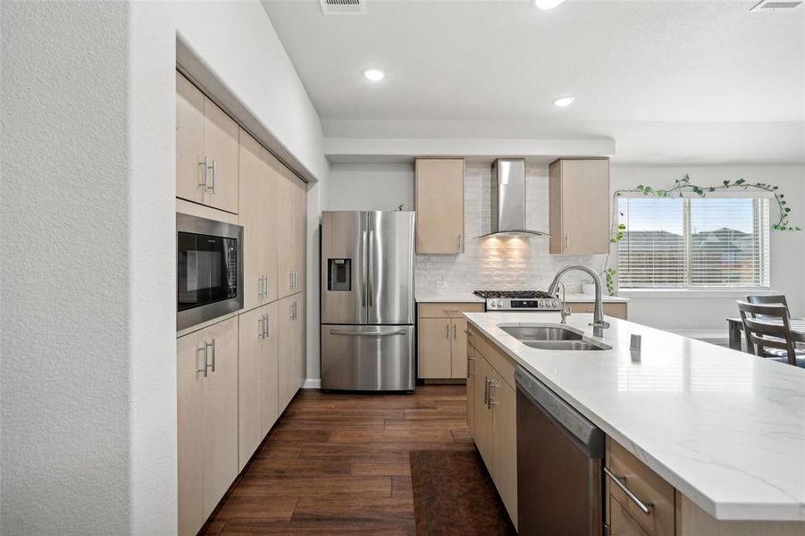 Kitchen with sink, wall chimney exhaust hood, tasteful backsplash, dark hardwood / wood-style flooring, and appliances with stainless steel finishes