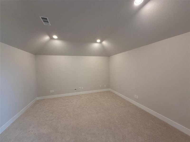 Empty room with light carpet, recessed lighting, and lofted ceiling Empty room with light carpet, recessed lighting, and lofted ceiling