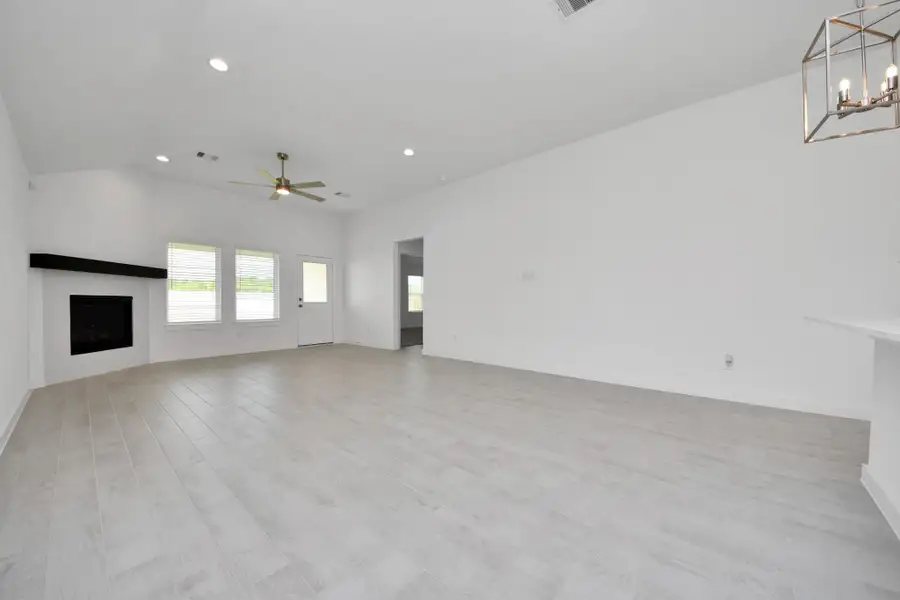 Gather the family and guests together in your lovely living room! Featuring soaring high ceilings, recessed lighting, ceiling fan, custom paint, gorgeous floors, and large windows that provide plenty of natural lighting throughout the day. Sample photo of completed home with similar floor plan. Actual colors and selections may vary.