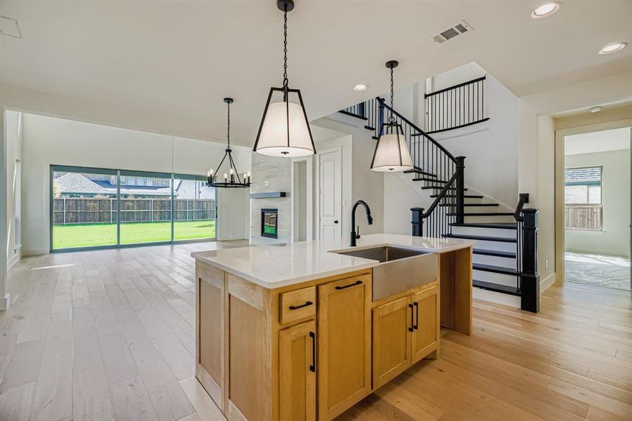 Kitchen with light wood finished floors, an island with sink, decorative light fixtures, a chandelier, and recessed lighting Kitchen with light wood finished floors, an island with sink, decorative light fixtures, a chandelier, and recessed lighting