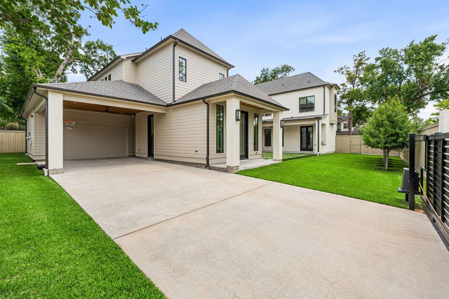A gated driveway entry enhances both privacy & security, opening to a double-wide drive w/ access to the porte-cochère and side-facing garage. Porte-cochère features a wood paneled ceiling and ceiling fan (ideal for hosting parties!). Thoughtfully designed for convenience, while maintaining a clean, polished exterior presence. The over-sized two garage features epoxy flooring for durability & easy maintenance. A gated driveway entry enhances both privacy & security, opening to a double-wide drive w/ access to the porte-cochère and side-facing garage. Porte-cochère features a wood paneled ceiling and ceiling fan (ideal for hosting parties!). Thoughtfully designed for convenience, while maintaining a clean, polished exterior presence. The over-sized two garage features epoxy flooring for durability & easy maintenance.