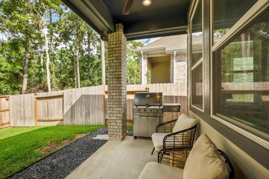 This covered patio is perfect for outdoor entertaining. It overlooks a fenced yard with lush green grass and mature trees, offering privacy and a natural setting. This covered patio is perfect for outdoor entertaining. It overlooks a fenced yard with lush green grass and mature trees, offering privacy and a natural setting.