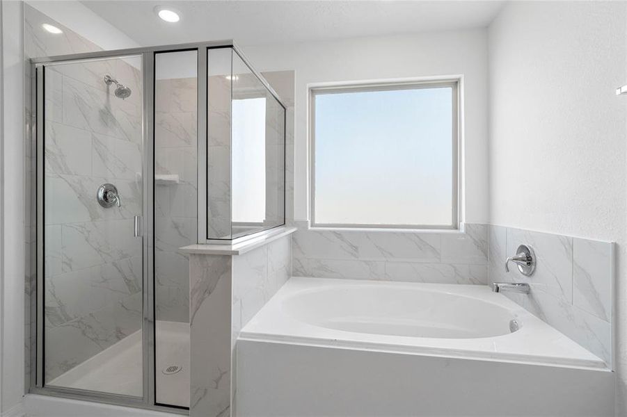 Additional view of the primary bathroom featuring an oversized framed walk-in shower with tile surround, separate garden tub for soaking after a long day with custom tile detailing, high ceilings, neutral paint, sleek and modern finishes.