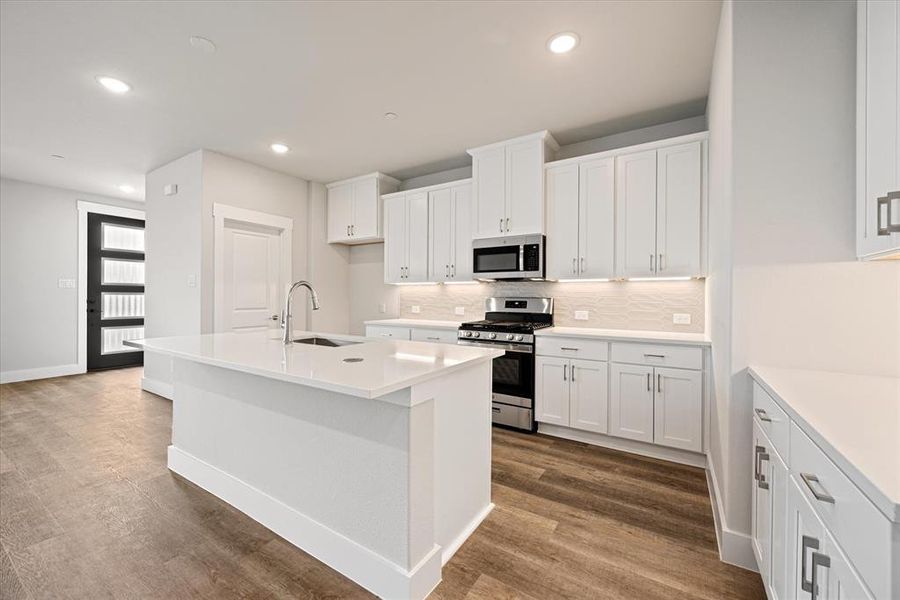 Your new dream kitchen features crisp clean white cabinets, quartz counters, wood look flooring and so much more!