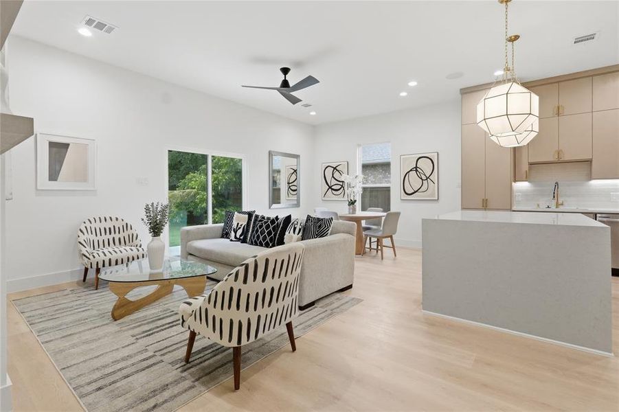 Open-concept living space featuring wood-finish flooring, recessed lighting, and a modern ceiling fan Open-concept living space featuring wood-finish flooring, recessed lighting, and a modern ceiling fan