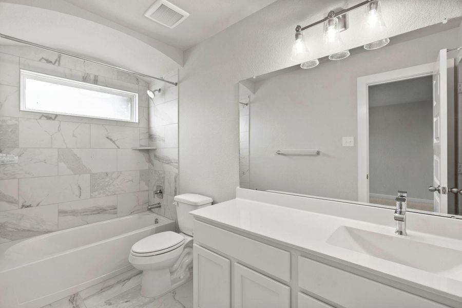 Experience sophistication in the secondary bathroom, where tile flooring complements a bath/shower combo with tile surround. Light wood cabinets complete with a beautiful light countertop, enhances the space for a truly inviting ambiance. Sample photo of completed home with similar floor plan. As-built interior colors and selections may vary. Experience sophistication in the secondary bathroom, where tile flooring complements a bath/shower combo with tile surround. Light wood cabinets complete with a beautiful light countertop, enhances the space for a truly inviting ambiance. Sample photo of completed home with similar floor plan. As-built interior colors and selections may vary.