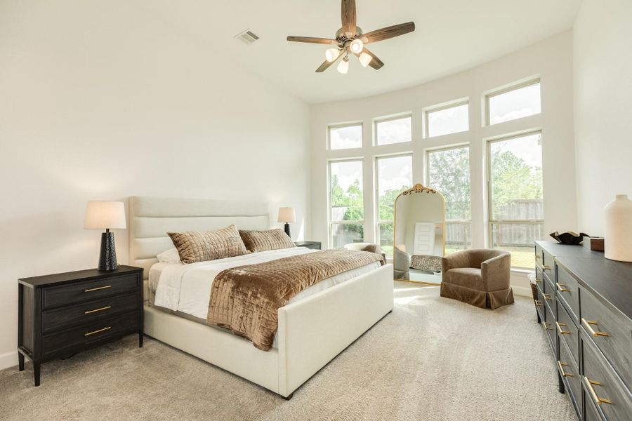 Primary bedroom located off the family area. This very spacious suite features a wall of floor-to-ceiling windows that provide serene views of the private backyard, which backs to a wooded common area with no rear neighbors. Primary bedroom located off the family area. This very spacious suite features a wall of floor-to-ceiling windows that provide serene views of the private backyard, which backs to a wooded common area with no rear neighbors.