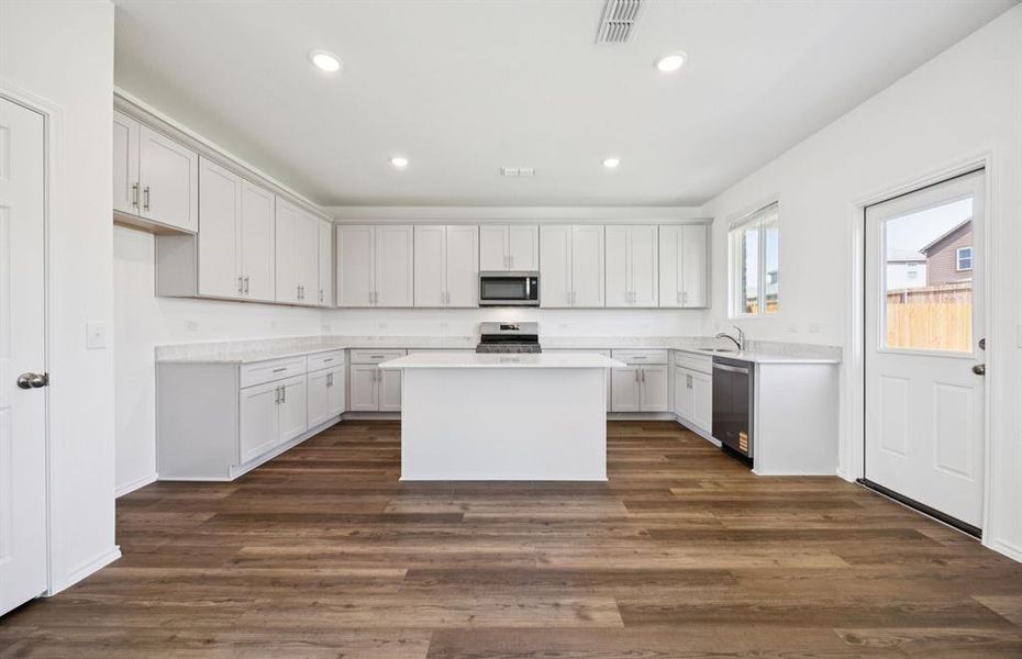 Large island overlooking gathering room and dining areas