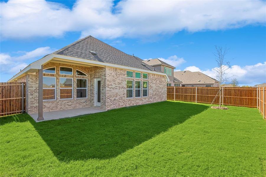 Back of house featuring a lawn and a patio area