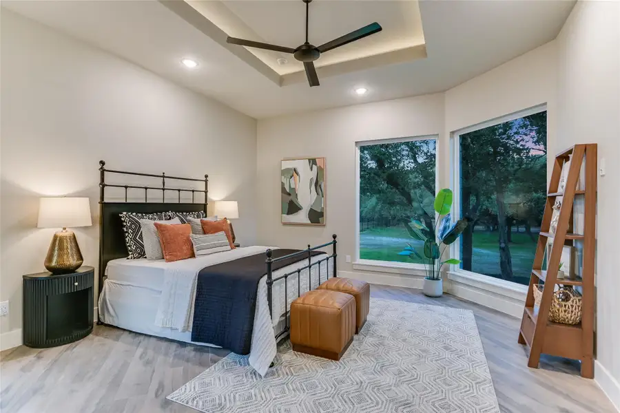 Bedroom with a raised ceiling, recessed lighting, and ceiling fan Bedroom with a raised ceiling, recessed lighting, and ceiling fan