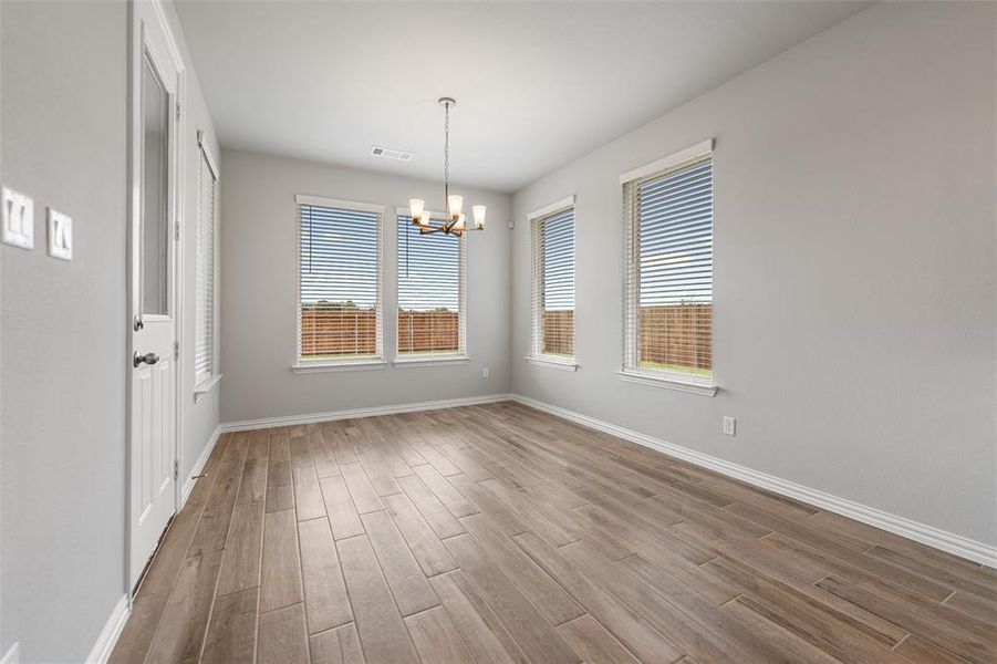 Unfurnished dining area with light wood finished floors, plenty of natural light, and a chandelier Unfurnished dining area with light wood finished floors, plenty of natural light, and a chandelier