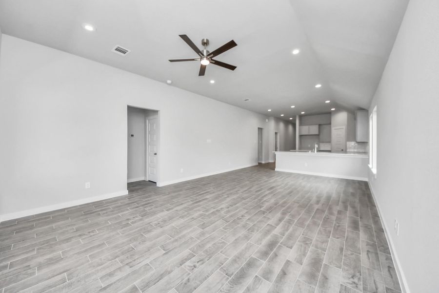 Welcome family and guests to your charming living room! With its high ceilings, recessed lighting, ceiling fan, custom paint, beautiful flooring, and large windows that let in abundant natural light, this room is perfect for gatherings. Sample photo of completed home with similar floor plan. Actual colors and selections may vary. Welcome family and guests to your charming living room! With its high ceilings, recessed lighting, ceiling fan, custom paint, beautiful flooring, and large windows that let in abundant natural light, this room is perfect for gatherings. Sample photo of completed home with similar floor plan. Actual colors and selections may vary.