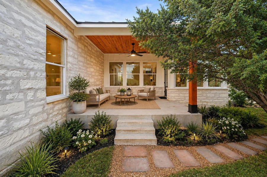 A welcoming covered porch with stone walls and a warm wood plank ceiling.Virtual Staging. A welcoming covered porch with stone walls and a warm wood plank ceiling.Virtual Staging.