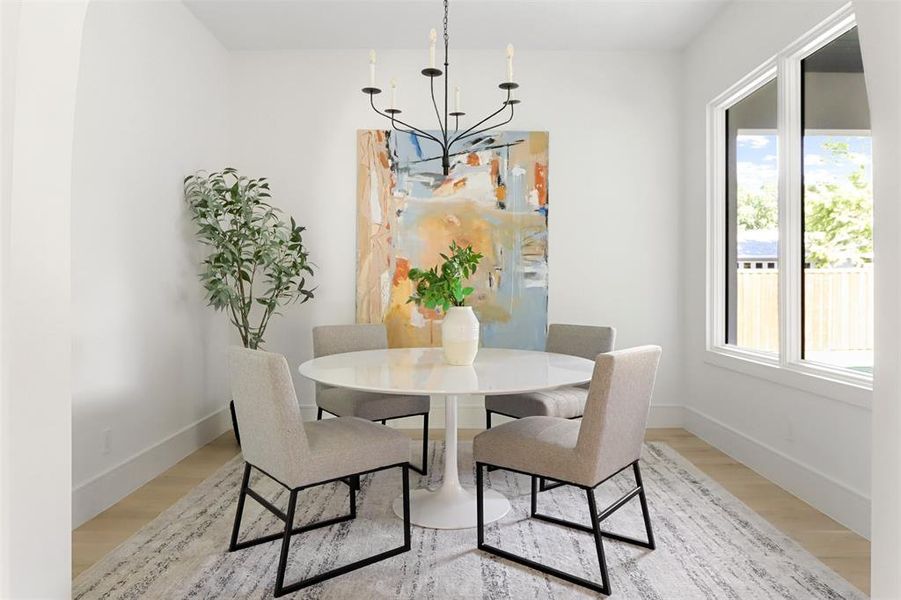 Dining room with a notable chandelier and light wood-type flooring