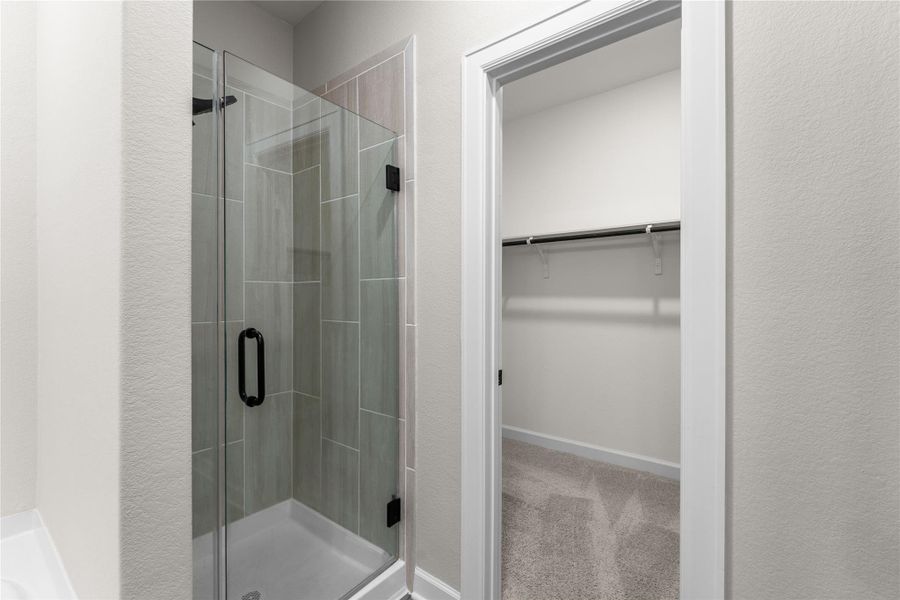 Spacious primary bath featuring granite countertops, a large vanity, soaking tub, separate walk-in shower, and an oversized walk-in closet. A comfortable retreat designed for both function and relaxation Spacious primary bath featuring granite countertops, a large vanity, soaking tub, separate walk-in shower, and an oversized walk-in closet. A comfortable retreat designed for both function and relaxation