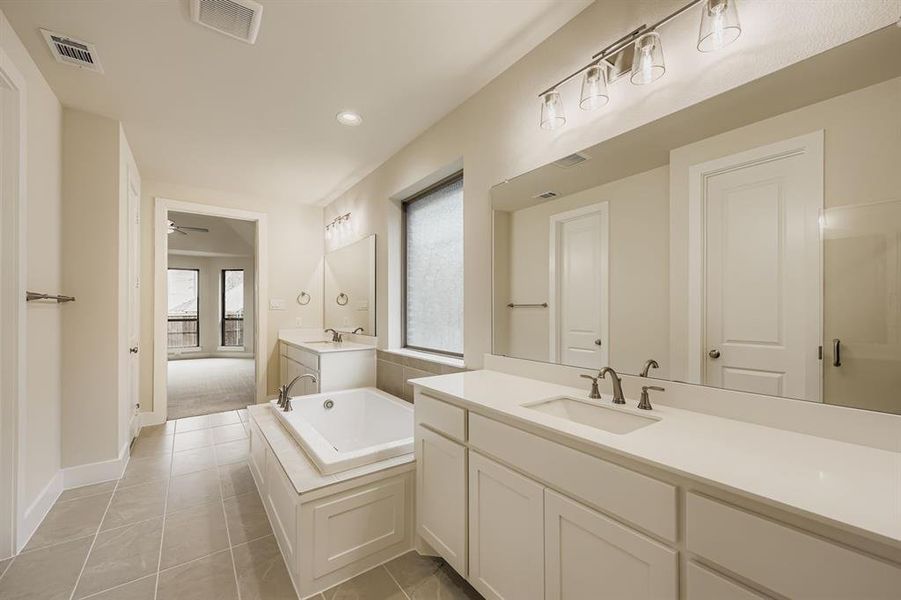 Bathroom featuring two vanities, a bath, light tile patterned flooring, recessed lighting, and ceiling fan