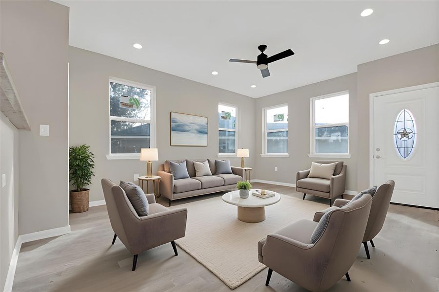 Living room with plenty of natural light, a ceiling fan, recessed lighting, and light wood finished floors