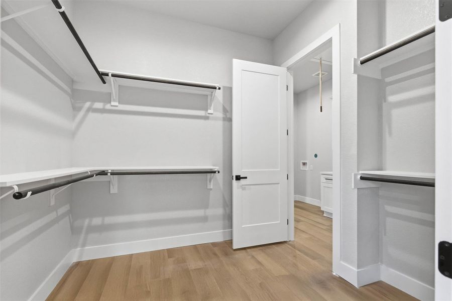 Walk in closet with dual entry from primary bath and laundry Walk in closet with dual entry from primary bath and laundry