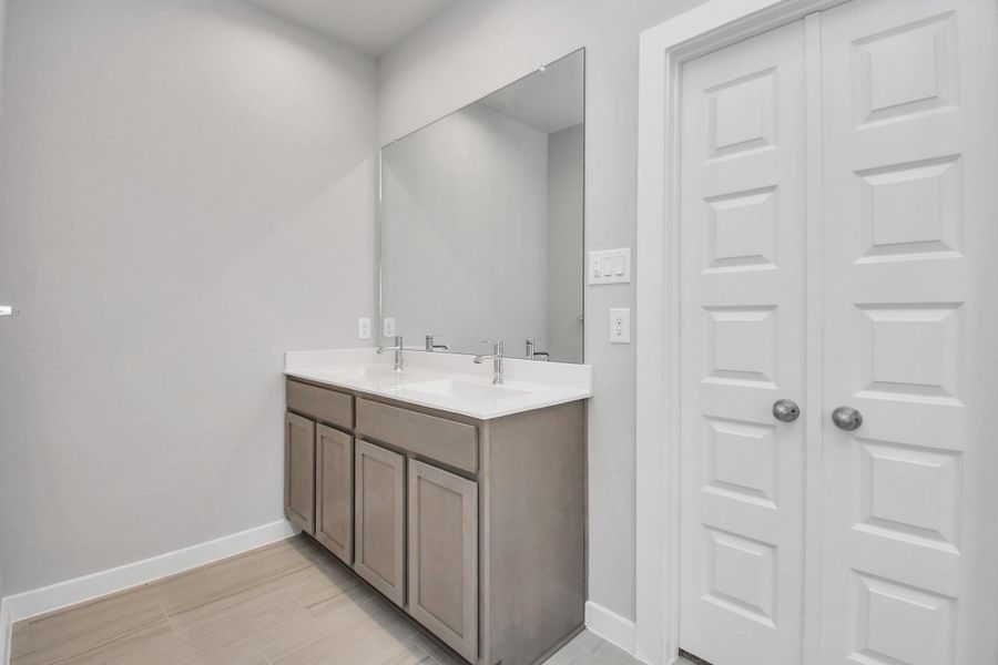 Elevate your daily routine at the elegant vanity, now equipped with double sinks, light countertops, modern hardware, and beautiful recessed lights.