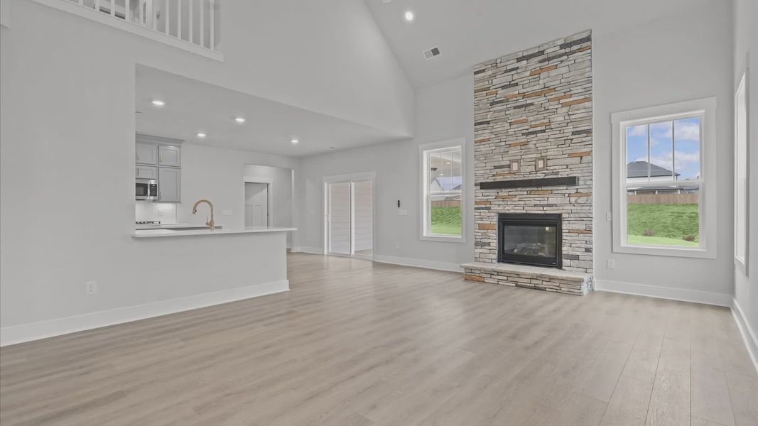 Accomplished design shines in this vibrant family room with dramatic two-story ceilings and open-concept flow