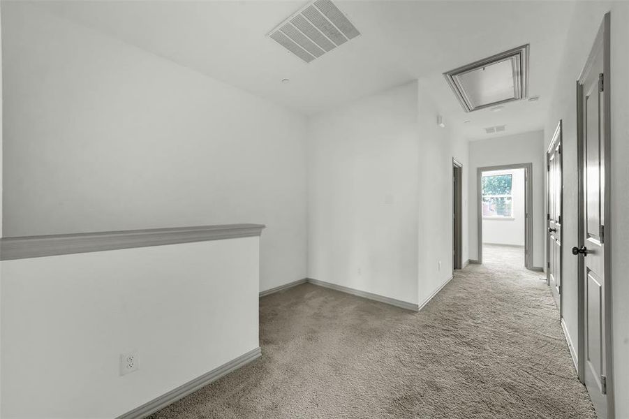 Empty room featuring attic access and light carpet Empty room featuring attic access and light carpet