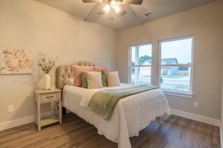 Bedroom featuring baseboards, wood finished floors, and ceiling fan