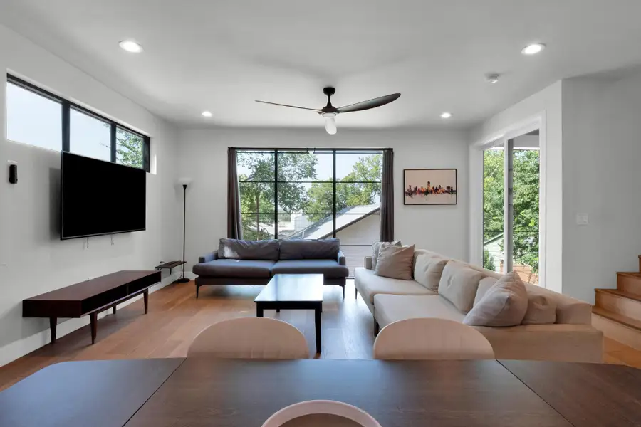 Living room with recessed lighting, a ceiling fan, and light wood-style flooring