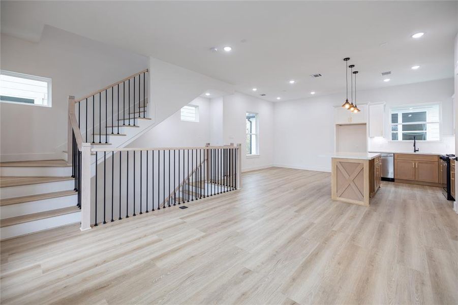 Alternate view of the open-concept living areas, featuring wood-like LVP flooring throughout, offering a sleek, carpet-free design.