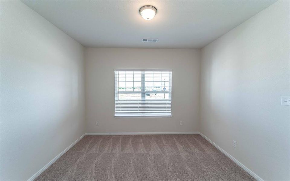 Room featuring neutral-toned carpet, a single window with blinds, and a flush-mount ceiling light fixture