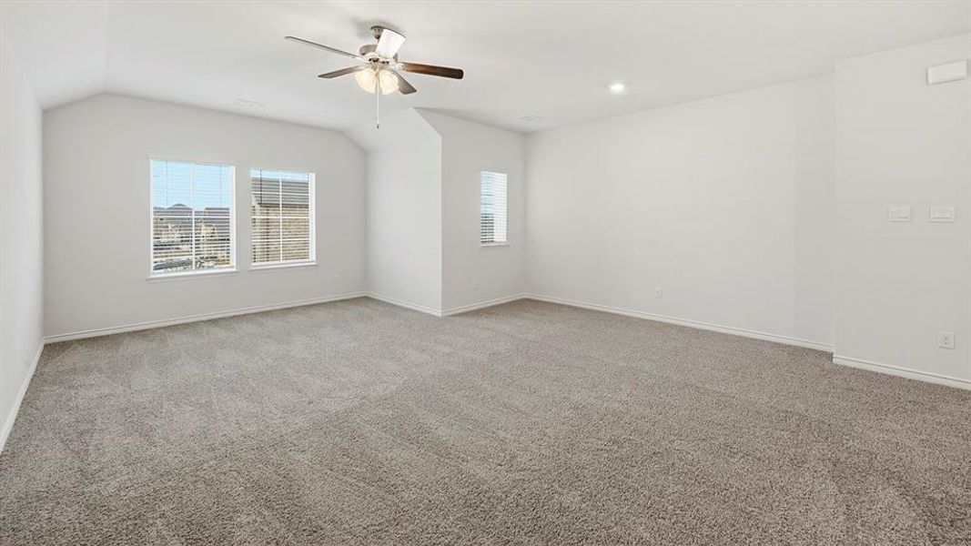 Spacious loft featuring plush grey carpeting, a multi-speed ceiling fan, recessed lighting, and a dark wood and iron railing overlooking the lower level
