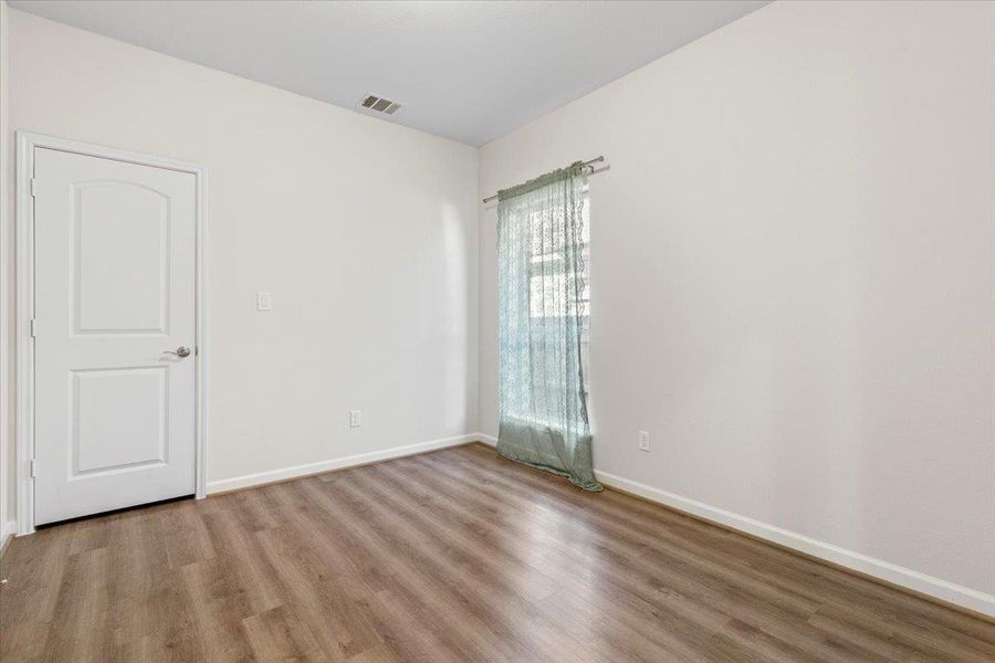 Empty room with light wood-style flooring and baseboards Empty room with light wood-style flooring and baseboards