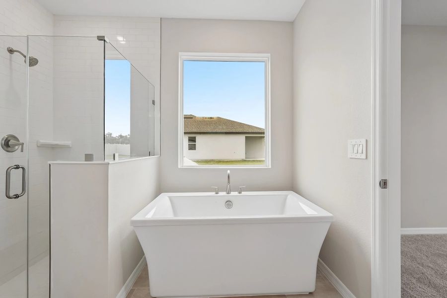 The primary bathroom features a stunning free standing tub