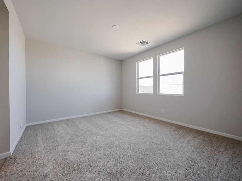 A room with a carpet and windows.