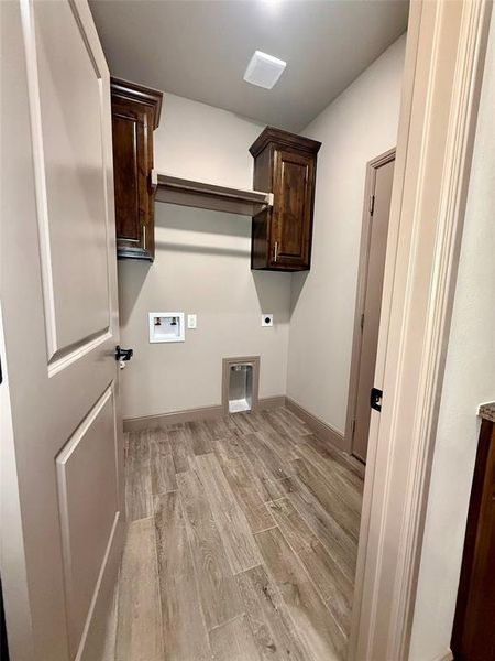 Dedicated utility space featuring wood-finish tile flooring and neutral wall tones Dedicated utility space featuring wood-finish tile flooring and neutral wall tones