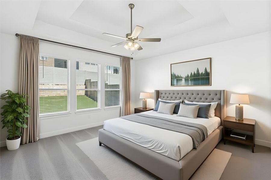 Bedroom with a raised ceiling and ceiling fan