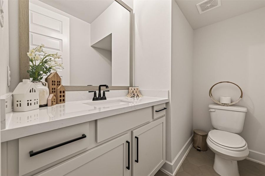 The conveniently located half bath is perfect for guests and everyday convenience. The conveniently located half bath is perfect for guests and everyday convenience.