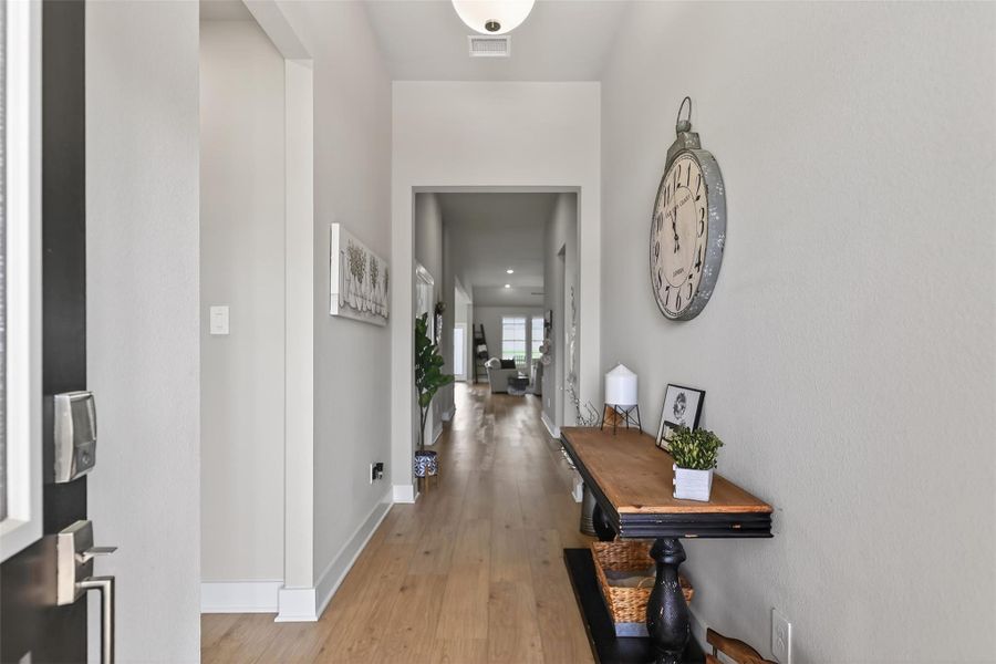 Welcome to your bright, inviting entryway with light wood flooring, neutral walls, and decorative accents.