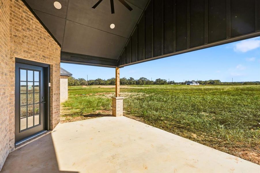 View of patio / terrace with ceiling fan and a view of countryside