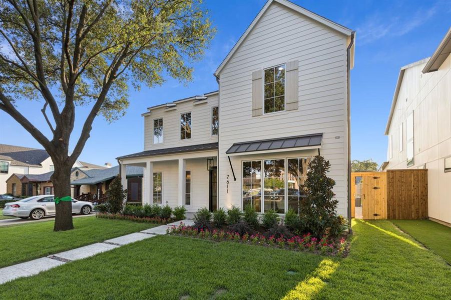 View of front of home with a standing seam roof, a gate, and a metal roof